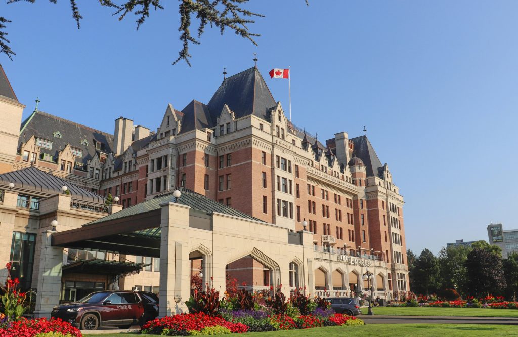 Historic Fairmont Empress Hotel with Canadian flag in Victoria, BC.